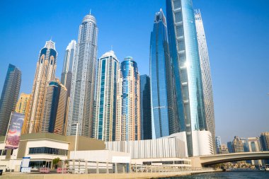 Dubai, BAE - 26 Ağustos 2024: Günbatımında Dubai Marina 'nın otelleri ve yerleşim yerleri. Tekneden panoramik görünüm