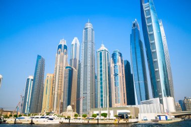 Dubai, BAE - 26 Ağustos 2024: Dubai Marina gökdelenleri gün batımında görülüyor. Tekneden panoramik görünüm