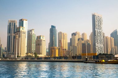 Dubai, BAE - 26 Ağustos 2024: Dubai Marina gökdelenleri gün batımında görülüyor. Tekneden panoramik görünüm