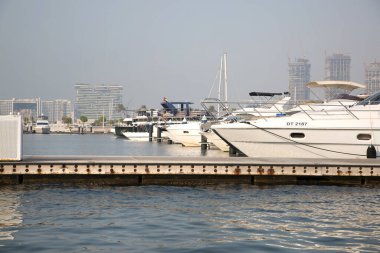 Dubai, BAE - 26 Ağustos 2024: Dubai Liman Yat Kulübü, gemiden manzara. Arka planda Dubai Marina gökdelenleri 