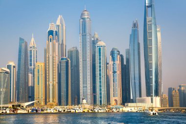 Dubai, BAE - 26 Ağustos 2024: Dubai Marina gökdelenleri gün batımında görülüyor. Tekneden panoramik görünüm