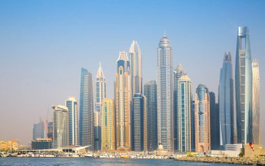 Dubai, BAE - 26 Ağustos 2024: Dubai Marina gökdelenleri gün batımında görülüyor. Tekneden panoramik görünüm