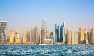 Dubai, BAE - 26 Ağustos 2024: Marina plajı, uzun oteller ve yerleşim yerleri. Tekneden panoramik görünüm