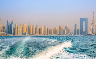 Dubai, BAE - 26 Ağustos 2024: Marina plajı, uzun oteller ve yerleşim yerleri. Tekneden panoramik görünüm