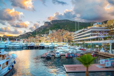Monaco, Monte Carlo - 15 Eylül 2023: Monako Prensliğinde Günbatımı. Limanın ve Monte Carlo şehrinin lüks yatları ve yelkenli tekneleri var.