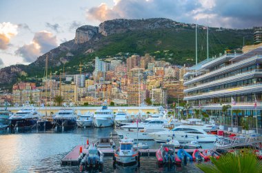 Monaco, Monte Carlo - 15 Eylül 2023: Monako Prensliğinde Günbatımı. Limanın ve Monte Carlo şehrinin lüks yatları ve yelkenli tekneleri var.