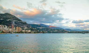 Monaco, Monte Carlo - 15 Eylül 2023: Monako Prensliğinde Günbatımı. Limanın ve Monte Carlo şehrinin lüks yatları ve yelkenli tekneleri var.