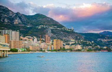 Monaco, Monte Carlo - 15 Eylül 2023: Monako Prensliğinde Günbatımı. Limanın ve Monte Carlo şehrinin lüks yatları ve yelkenli tekneleri var.