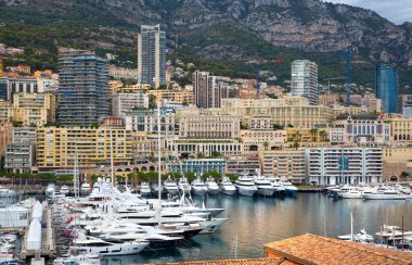 Monaco, Monte Carlo - 15 Eylül 2023: Monako Prensliğinde Günbatımı. Limanın ve Monte Carlo şehrinin lüks yatları ve yelkenli tekneleri var.