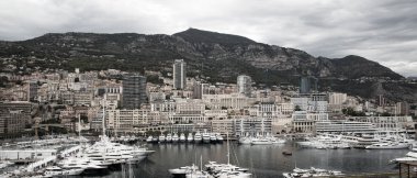 Monaco, Monte Carlo - 15 Eylül 2023: Monako Prensliğinde Günbatımı. Limanın ve Monte Carlo şehrinin lüks yatları ve yelkenli tekneleri var.