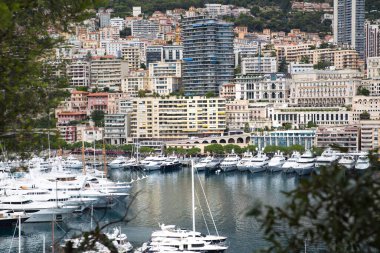 Monaco, Monte Carlo - 15 Eylül 2023: Monako Prensliğinde Günbatımı. Limanın ve Monte Carlo şehrinin lüks yatları ve yelkenli tekneleri var.