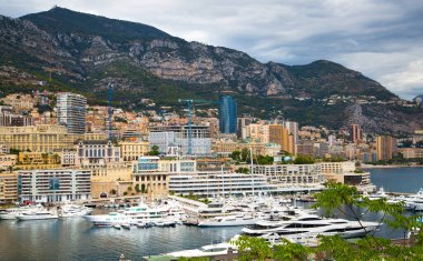 Monaco, Monte Carlo - 15 Eylül 2023: Monako Prensliğinde Günbatımı. Limanın ve Monte Carlo şehrinin lüks yatları ve yelkenli tekneleri var.