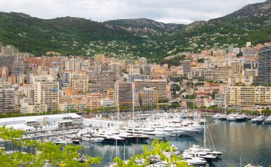 Monaco, Monte Carlo - 15 Eylül 2023: Monako Prensliğinde Günbatımı. Limanın ve Monte Carlo şehrinin lüks yatları ve yelkenli tekneleri var.
