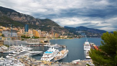 Monaco, Monte Carlo - 15 Eylül 2023: Monako Prensliğinde Günbatımı. Limanın ve Monte Carlo şehrinin lüks yatları ve yelkenli tekneleri var.
