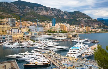 Monaco, Monte Carlo - 15 Eylül 2023: Monako Prensliğinde Günbatımı. Limanın ve Monte Carlo şehrinin lüks yatları ve yelkenli tekneleri var.