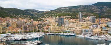 Monaco, Monte Carlo - 15 Eylül 2023: Monako Prensliğinde Günbatımı. Limanın ve Monte Carlo şehrinin lüks yatları ve yelkenli tekneleri var.