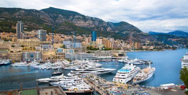 Monaco, Monte Carlo - 15 Eylül 2023: Monako Prensliğinde Günbatımı. Limanın ve Monte Carlo şehrinin lüks yatları ve yelkenli tekneleri var.