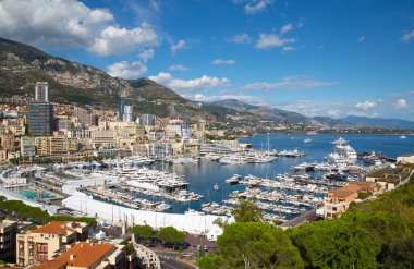 Monaco, Monte Carlo - 17 Eylül 2023: lüks tekneleri ve yatları olan Monaco Herkül limanında panoramik manzara. Güneşli bir günde Monako şehri manzarası