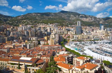 Monaco, Monte Carlo - 17 Eylül 2023: lüks tekneleri ve yatları olan Monaco Herkül limanında panoramik manzara. Güneşli bir günde Monako şehri manzarası
