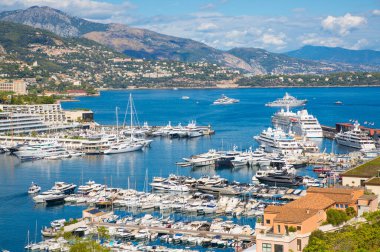 Monaco, Monte Carlo - 17 Eylül 2023: lüks tekneleri ve yatları olan Monaco Herkül limanında panoramik manzara. Güneşli bir günde Monako şehri manzarası