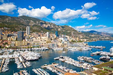 Monaco, Monte Carlo - 17 Eylül 2023: lüks tekneleri ve yatları olan Monaco Herkül limanında panoramik manzara. Güneşli bir günde Monako şehri manzarası