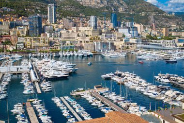 Monaco, Monte Carlo - 17 Eylül 2023: lüks tekneleri ve yatları olan Monaco Herkül limanında panoramik manzara. Güneşli bir günde Monako şehri manzarası