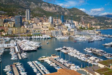Monaco, Monte Carlo - 17 Eylül 2023: lüks tekneleri ve yatları olan Monaco Herkül limanında panoramik manzara. Güneşli bir günde Monako şehri manzarası