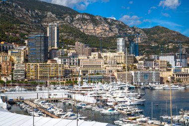 Monaco, Monte Carlo - 17 Eylül 2023: lüks tekneleri ve yatları olan Monaco Herkül limanında panoramik manzara. Güneşli bir günde Monako şehri manzarası