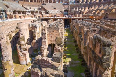 ROME, ITALY - 6 Nisan 2024: Kolezyum harabeleri, gladyatör odaları ve hayvan kafeslerinin yeraltı seviyeleriyle panoramik manzara