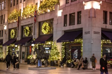 Londra, İngiltere - 8 Kasım 2024: Bond Caddesi 'nde Noel ışıkları. Londra Noel ve 2025 yılbaşı kutlamaları için aydınlatıldı. Kalabalık cadde, insanlar ışıkların tadını çıkarıyor ve alışveriş yapıyorlar. 