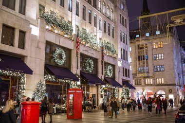 Londra, İngiltere - 8 Kasım 2024: Bond Caddesi 'nde Noel ışıkları. Londra Noel ve 2025 yılbaşı kutlamaları için aydınlatıldı. Kalabalık cadde, insanlar ışıkların tadını çıkarıyor ve alışveriş yapıyorlar. 