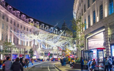 Londra, İngiltere - 8 Kasım 2024: Noel Ruhu, Regent sokağı Noel ışıkları, Londra 2025 için aydınlatıldı. Kalabalık cadde, insanlar ışıkların tadını çıkarıyor, yürüyor, alışveriş yapıyor. 