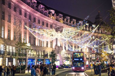 Londra, İngiltere - 8 Kasım 2024: Noel Ruhu, Regent sokağı Noel ışıkları, Londra 2025 için aydınlatıldı. Kalabalık cadde, insanlar ışıkların tadını çıkarıyor, yürüyor, alışveriş yapıyor. 