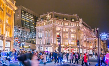 Londra, İngiltere - 8 Kasım 2024: Oxford sirkinde Noel ışıkları Noel ve 2025 yılbaşı kutlamaları için aydınlatıldı. Kalabalık cadde, insanlar ışıkların tadını çıkarıyor ve alışveriş yapıyorlar. 