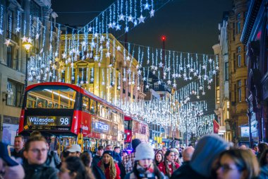 Londra, İngiltere - 8 Kasım 2024: Oxford sirkinde Noel ışıkları Noel ve 2025 yılbaşı kutlamaları için aydınlatıldı. Kalabalık cadde, insanlar ışıkların tadını çıkarıyor ve alışveriş yapıyorlar. 