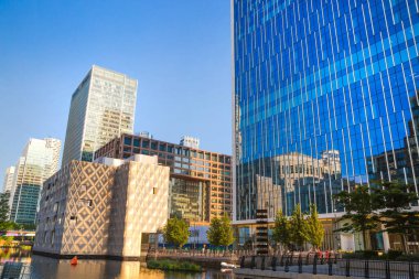 Londra, İngiltere - 30 Temmuz 2024: Canary Wharf işi ve günbatımında kurumsal gökdelenleri olan bankacılık.