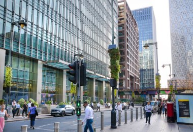 Londra, İngiltere - 30 Temmuz 2024: Canary Wharf işi ve gün batımında bankacılık. Metroyla sokak manzarası, yeraltı girişi