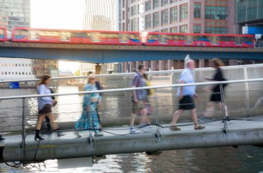 Londra, İngiltere - 30 Temmuz 2024: Canary Wharf 'tan geçen insanların hareket bulanıklığı. Gün batımında şehir merkezinde iş ve bankacılık