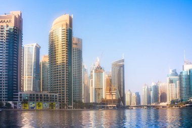 Dubai, BAE - 26 Ağustos 2024: Dubai Marina gökdelenleri gün batımında görülüyor. Tekneden panoramik görünüm