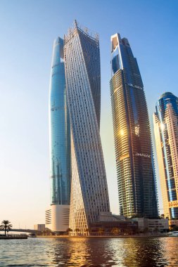 Dubai, BAE - 26 Ağustos 2024: Dubai Marina gökdelenleri gün batımında görülüyor. Tekneden panoramik görünüm