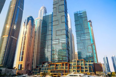 Dubai, BAE - 26 Ağustos 2024: Dubai Marina gökdelenleri gün batımında görülüyor. Tekneden panoramik görünüm