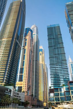 Dubai, BAE - 26 Ağustos 2024: Dubai Marina gökdelenleri gün batımında görülüyor. Tekneden panoramik görünüm