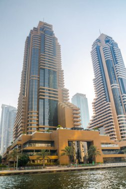 Dubai, BAE - 26 Ağustos 2024: Dubai Marina gökdelenleri gün batımında görülüyor. Tekneden panoramik görünüm