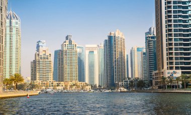 Dubai, BAE - 26 Ağustos 2024: Dubai Marina gökdelenleri gün batımında görülüyor. Tekneden panoramik görünüm