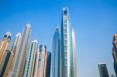 Dubai, BAE - 26 Ağustos 2024: Dubai Marina gökdelenleri gün batımında görülüyor. Tekneden panoramik görünüm