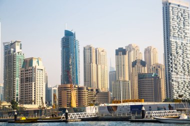 Dubai, BAE - 26 Ağustos 2024: Dubai Marina gökdelenleri gün batımında görülüyor. Tekneden panoramik görünüm
