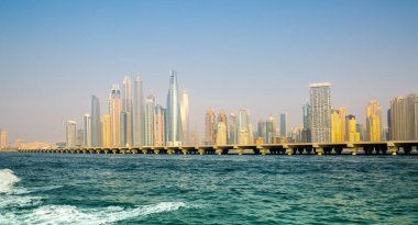 Dubai, BAE - 26 Ağustos 2024: Dubai Marina gökdelenleri gün batımında görülüyor. Tekneden panoramik görünüm