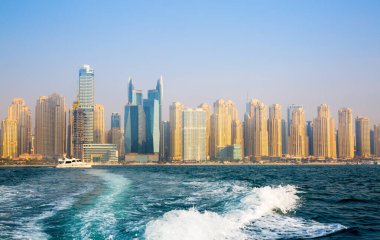 Dubai, BAE - 26 Ağustos 2024: Dubai Marina gökdelenleri gün batımında görülüyor. Tekneden panoramik görünüm