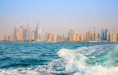 Dubai, BAE - 26 Ağustos 2024: Dubai Marina gökdelenleri gün batımında görülüyor. Tekneden panoramik görünüm
