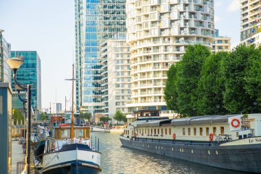  Londra, İngiltere - 14 Haziran 2025: Günbatımında Canary Wharf, Güney rıhtımında yelkenli tekne 